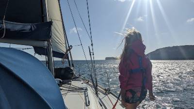 Image of a girl looking out over the sea from a sailboat
